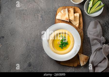 Hummus tradizionale con piselli di neve e ceci, con acqua e verdure fresche Foto Stock