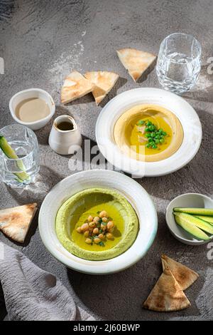 Hummus tradizionale con piselli di neve e ceci, con acqua e verdure fresche Foto Stock