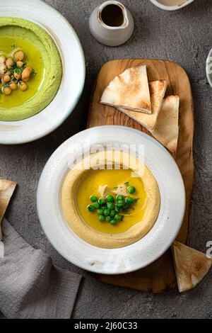 Hummus tradizionale con piselli di neve e ceci, con acqua e verdure fresche Foto Stock
