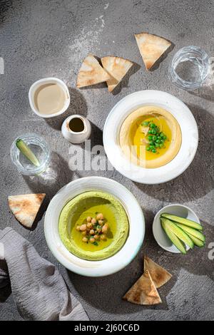 Hummus tradizionale con piselli di neve e ceci, con acqua e verdure fresche Foto Stock