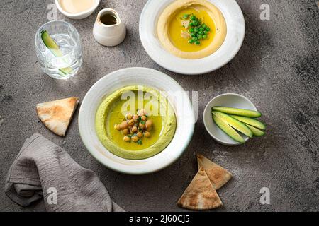 Hummus tradizionale con piselli di neve e ceci, con acqua e verdure fresche Foto Stock