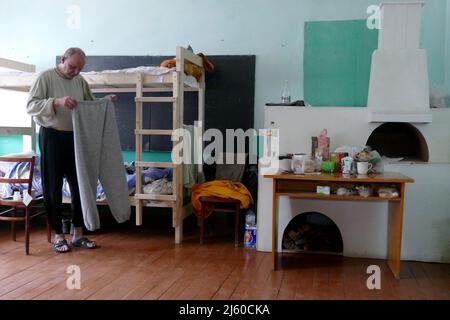 Non esclusiva: DOVHOPOLE, UCRAINA - 25 APRILE 2022 - un uomo vive nella palestra di una scuola locale che è diventata casa di sfollati della regione di Kiev, Foto Stock