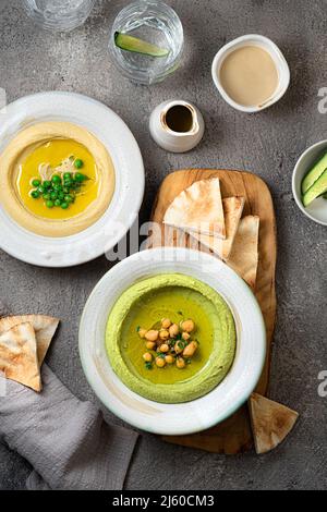 Hummus tradizionale con piselli di neve e ceci, con acqua e verdure fresche Foto Stock