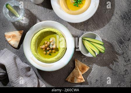 Hummus tradizionale con piselli di neve e ceci, con acqua e verdure fresche Foto Stock