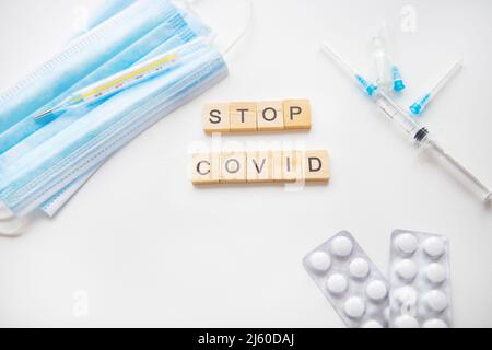 Fermare l'iscrizione del coronavirus. Preparazione per la vaccinazione contro covid-19. Siringa, vaccino, pillole, maschera medica Foto Stock