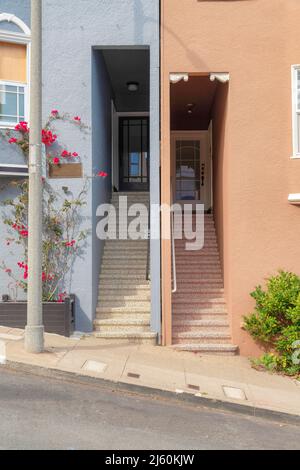 Case di quartiere con scala alla porta d'ingresso su un pendio di cemento zona residenziale Foto Stock