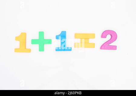 Matematica uno più uno è uguale a due dei numeri colorati su sfondo bianco Foto Stock