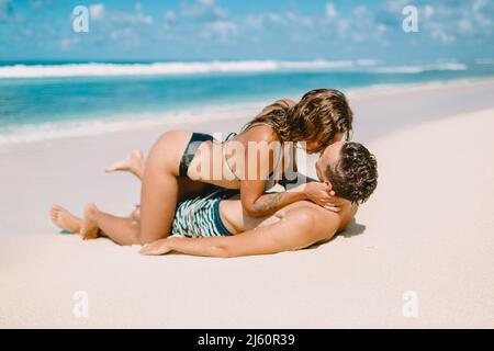 Gennaio 28, 2020. Bali, Indonesia. Una giovane coppia bacia sulla spiaggia tropicale dell'oceano. Foto Stock