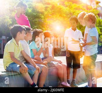 Sorridendo i bambini che chiacchierano e si divertono all'aperto in città Foto Stock