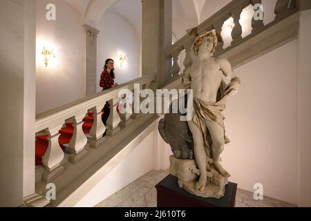 Dresda, Germania. 26th Apr 2022. Un interno delle collezioni d'arte statale di Dresda (SKD) guarda un Hermes barocco appena restaurato da Zittau dalla scalinata inglese nel Residence Palace. Il messaggero in pietra degli dei di una delle case di sepoltura dell'ex cimitero del monastero è in mostra ai piedi della scalinata inglese nel Palazzo del Residence di Dresda fino a metà settembre, annunciando la ricchezza della provincia sassone. Credit: Robert Michael/dpa/Alamy Live News Foto Stock