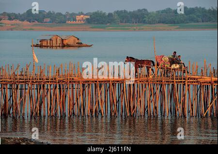 Cavallo di overload carrello attraversa il ponte di bambù sul fiume Mekong (houseboat in background), Kampong Cham, Cambogia. Credito: Kraig Lieb Foto Stock