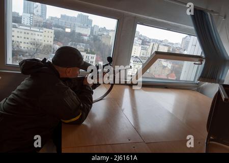 KIEV, UCRAINA 02 marzo. Un cecchino del battaglione di difesa di Kyiv punta il suo fucile mentre prende posizione in un piano superiore di un edificio di uffici, mentre i funzionari temono che i sabotatori russi attaccheranno le infrastrutture della città e causeranno panico durante l'invasione russa dell'Ucraina il 02 marzo 2022 a Kiev, Ucraina. La Russia ha iniziato un'invasione militare dell'Ucraina dopo che il parlamento russo ha approvato trattati con due regioni separatiste nell'Ucraina orientale. E' il più grande conflitto militare in Europa dalla seconda guerra mondiale Foto Stock