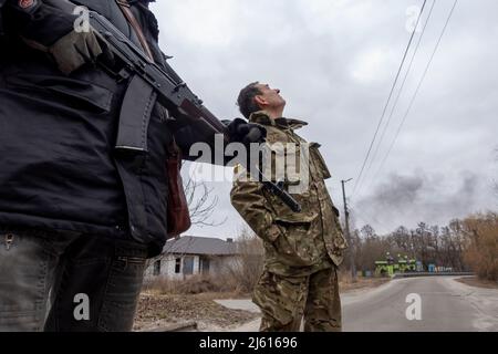 HORENKA, UCRAINA 07 marzo. Un membro delle forze di difesa territoriale osserva il fumo che sale dopo essere stato gridato nei pressi del villaggio frontline di Horenka, a nord della capitale di Kyiv, mentre l'invasione russa dell'Ucraina continua il 07 marzo 2022 a Horenka, Ucraina. La Russia ha iniziato un'invasione militare dell'Ucraina dopo che il parlamento russo ha approvato i trattati con due regioni in distacco nell'Ucraina orientale. È il più grande conflitto militare in Europa dalla seconda guerra mondiale Foto Stock