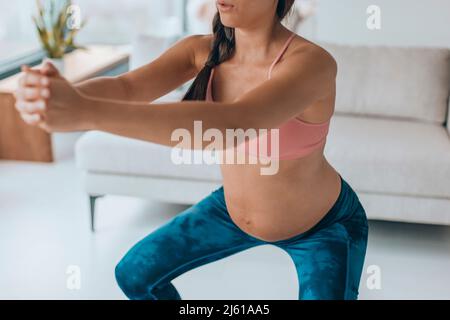 Gravidanza allenamento donna facendo squat glutes esercizi a casa. Formazione prenatale di idoneità per le donne incinte Foto Stock