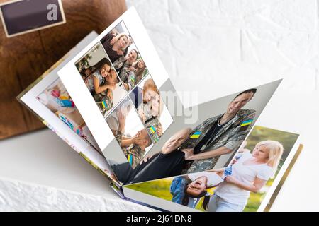 su tavola bianca aperto fotobook da foto sparare di famiglia con bandiera ucraina Foto Stock