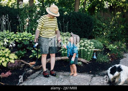 Nonna con nipote in piedi in giardino Foto Stock