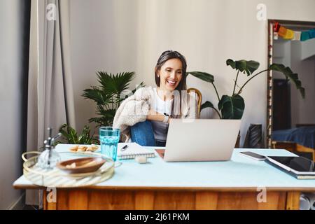 Una donna felice che ha una videochiamata sul laptop a casa Foto Stock
