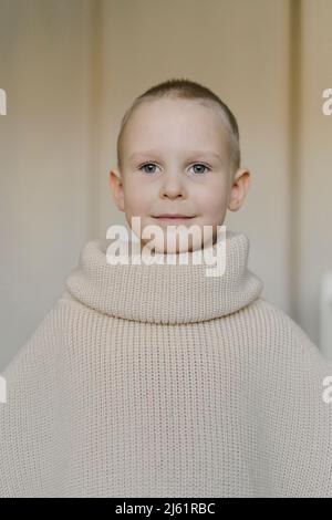 Ragazzo sorridente che indossa un pullover grande con dolcevita Foto Stock