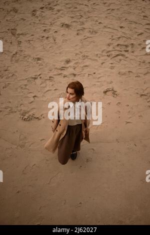 Giovane donna in piedi sulla sabbia in spiaggia Foto Stock
