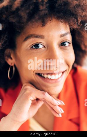 Imprenditrice sorridente con la mano sul mento Foto Stock