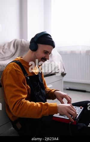 Uomo che indossa le cuffie utilizzando il pianoforte a casa Foto Stock