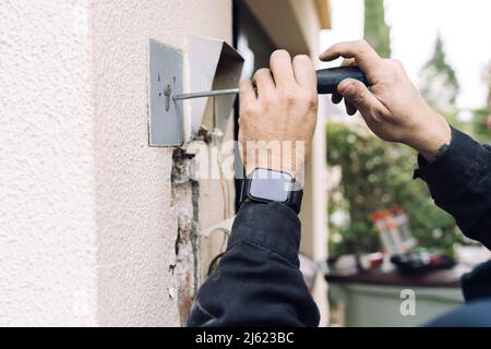 Le mani del lavoratore di costruzione usando il cacciavite sulla parete Foto Stock