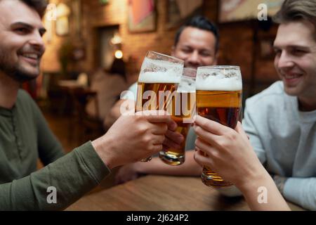 Amici che si incontrano in un pub e calici bicchieri da birra Foto Stock