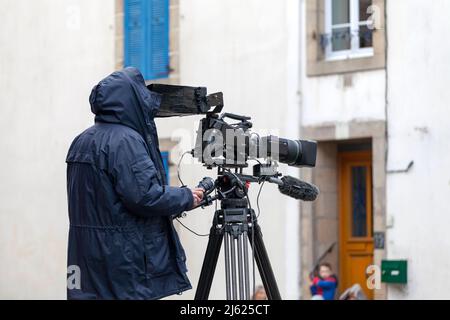 Douarnenez, Francia - Febbraio 27 2022: Cameraman filma per un canale televisivo locale durante Les Gras de Douarnenez. Foto Stock