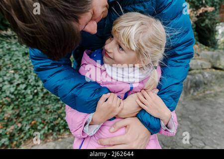 Felice padre che abbraccia la figlia all'aperto Foto Stock