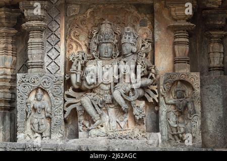 La scultura di Lord Shiva e Parvati sul Tempio di Hoysaleswara, Halebeedu, Karnataka, India Foto Stock