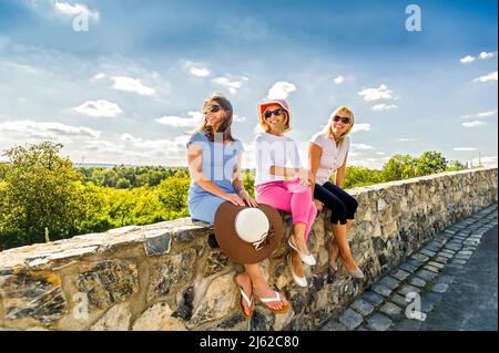 tre donne sedute sul muro di pietra godendo il coutriside Foto Stock