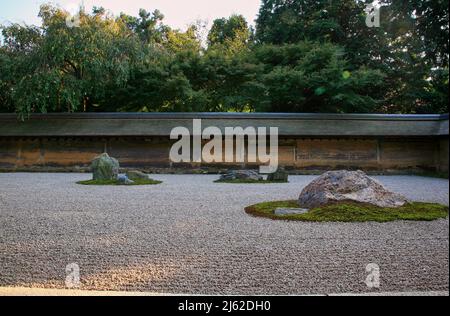 La vista di gruppi separati di massi circondati dalle onde di ghiaia bianca nel famoso giardino di pietra Zen del tempio Ryoan-ji. Kyoto. Giappone Foto Stock