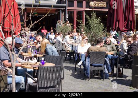 Nijmegen, Paesi Bassi - 16 aprile 2022: La gente si rilassa e si sorseggia un drink in una caffetteria all'aperto nel centro di Nijmegen Foto Stock