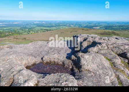 Regno Unito, Inghilterra, Devonshire, Dartmoor. Un bacino di roccia sulla cima di Heytor Rocks. Guardando verso il mare. Foto Stock