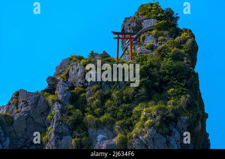 Primo piano della porta Torii e della corda Shimenawa situata in cima alla roccia più grande (catasta di mare) delle tre rocce Mitsuishi. Foto Stock