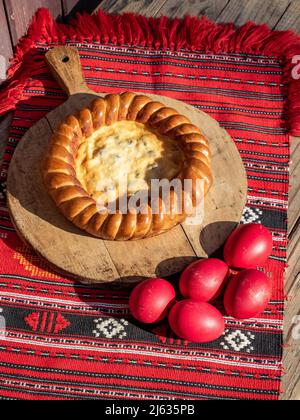 uova rosse di pasqua e pane dolce conosciuto come pasca in rumeno Foto Stock