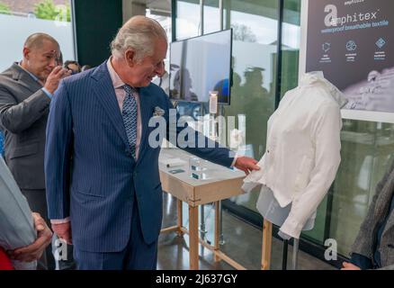 Il Prince of Wales ritiene che la blusa realizzata con Amphitex sia un tessuto traspirante impermeabile, mentre vede alcuni dei progetti vincenti per il concorso inaugurale Terra carta Design Lab per aiutare il cambiamento climatico, al Royal College of Art Dyson Gallery di Londra. Data foto: Mercoledì 27 aprile 2022. Foto Stock