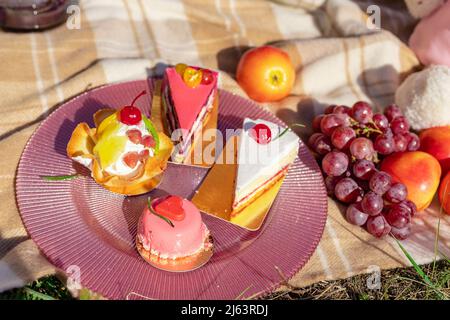 Composizione su un copriletto di dolci, uva e pesche Foto Stock