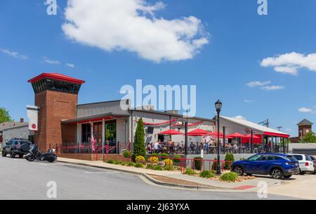 GREER, SC, USA 24 APRILE 2022: Vista sulla strada del Wild Ace Pizza & Pub nelle giornate di sole, con area salotto all'aperto affollata di clienti. Foto Stock