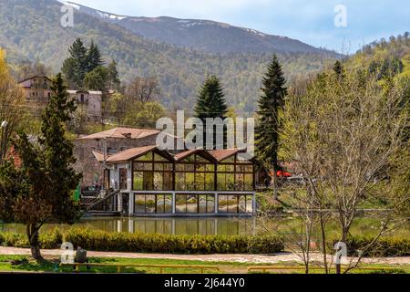 Dilijan, Armenia - 25 Aprile 2022 - Vista del Cafe numero 2 caffetteria presso un lago a Dilijan, Armenia con alte montagne sullo sfondo Foto Stock