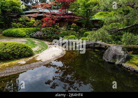 Kyoto Prefectural Guest House Garden - questo piccolo giardino è centrale intorno ad un laghetto carpe con una teahouse che si affaccia su una collina sullo sfondo. Là Foto Stock