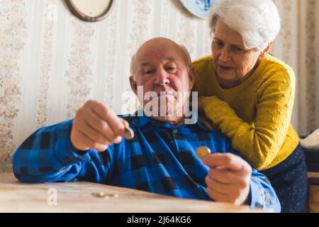 senior couple contando ultimi centesimi medio colpo soggiorno concetto denaro. Foto di alta qualità Foto Stock