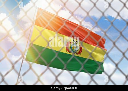 Una rete di acciaio sullo sfondo di un cielo blu e un flagpole con la bandiera della bolivia Foto Stock