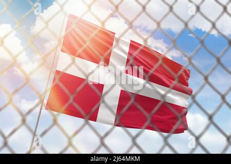 Una rete d'acciaio sullo sfondo di un cielo blu e un flagpole con la bandiera della danimarca Foto Stock