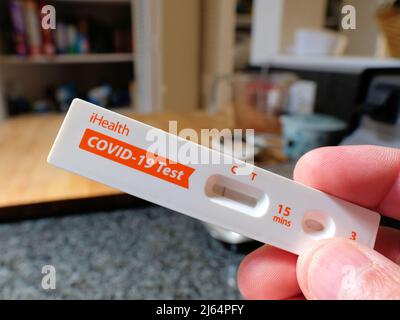 La mano della persona che tiene una scheda di auto-test antigenico rapido di iHealth COVID-19 in-home che mostra un risultato negativo di Coronavirus; a casa. Foto Stock