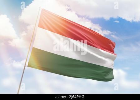 Cielo azzurro soleggiato e un flagpole con la bandiera dell'ungheria Foto Stock