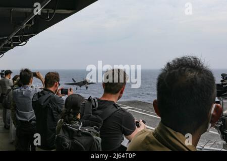 PHILIPPINE SEA (23 aprile 2022) membri di media internazionali operazioni di volo cinematografico a bordo del vettore aereo di classe Nimitz USS Abraham Lincoln (CVN 72). Abraham Lincoln Strike Group è in fase di implementazione pianificata nell'area delle operazioni della flotta USA 7th per migliorare l'interoperabilità attraverso alleanze e partnership, fungendo da forza di risposta pronta a supportare una regione indopacifica libera e aperta. (STATI UNITI Foto Navy di Sint. Di comunicazione di massa Seaman Aprentice Julia Brockman) Foto Stock