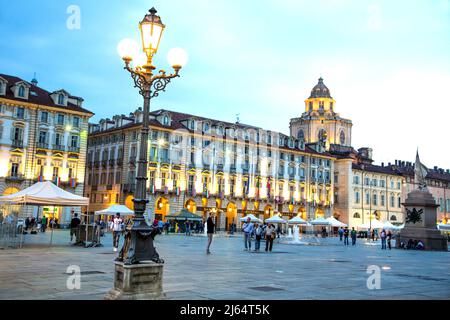 I visitatori e gli abitanti locali facendo una passeggiata serale attorno a Piazza Castello a Torino Italia. Foto Stock