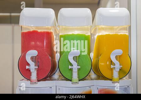 Tre dispenser di succhi di frutta per bevande analcoliche colorate Foto Stock