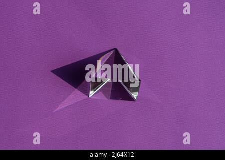Luce rifrangente a prisma di cristallo, cristalli magici e piramide, sfera e cubo su sfondo viola. Pratica di cristallo di guarigione spirituale. Feng Shui, bravo Foto Stock